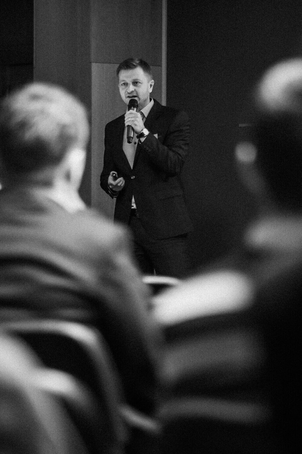 Fotograf eventů, konferencí a večírků v Praze - na fotografii je přednášející muž na konferenci, který čte prezentaci